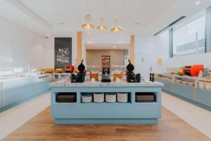 华沙Hampton By Hilton Warsaw Reduta的厨房配有蓝色橱柜和食品柜台。