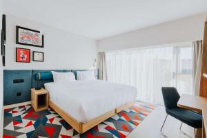 华沙Hampton By Hilton Warsaw Reduta的一间卧室配有一张床、一张桌子和一把椅子