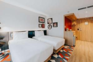 华沙Hampton By Hilton Warsaw Reduta的配有白色床单的酒店客房内的两张床