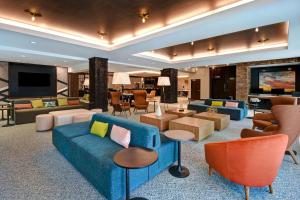 卡拉马祖Hilton Garden Inn Kalamazoo Downtown的客厅配有蓝色的沙发和椅子