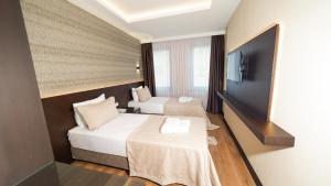 伊斯坦布尔Bellezza Hotel的酒店客房设有两张床和一台平面电视。