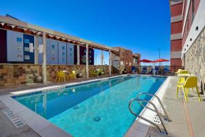 奥德萨Home2 Suites By Hilton Odessa的一座配有桌椅的酒店游泳池