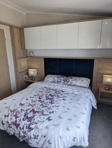 斯沃尼奇Caravan Swanage Bay View Holiday Park Dorset Amazing Location的一间卧室配有一张大床和蓝色床头板
