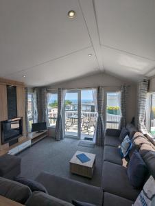 斯沃尼奇Caravan Swanage Bay View Holiday Park Dorset Amazing Location的带沙发和电视的客厅