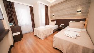 伊斯坦布尔Bellezza Hotel的酒店客房,设有两张床和两张桌子