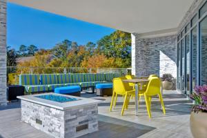 萨凡纳Home2 Suites By Hilton Savannah Midtown, Ga的享有美景的庭院设有黄色椅子和桌子。
