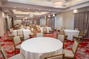 汉诺瓦Hilton Garden Inn Hanover Arundel Mills, MD的宴会厅配有白色的桌椅