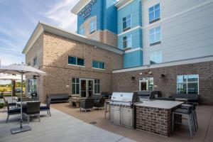 默特尔比奇Homewood Suites By Hilton Myrtle Beach Coastal Grand Mall的一座配有桌椅的庭院和一座建筑