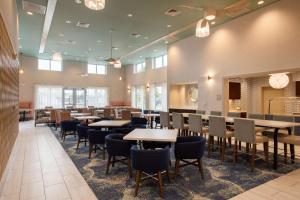 默特尔比奇Homewood Suites By Hilton Myrtle Beach Coastal Grand Mall的用餐室设有桌椅和窗户。
