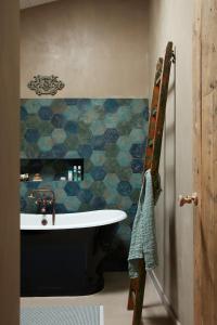 雷岛林滩Maisons 322 - L'Insolite的带浴缸的浴室和蓝色瓷砖墙