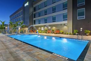 迈尔斯堡Home2 Suites by Hilton Fort Myers Colonial Blvd的大楼前的大型游泳池