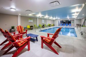 刘易斯堡Home2 Suites By Hilton Lewisburg, Wv的一个带桌椅的游泳池和一个游泳池