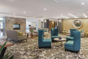 莱瑟姆Hotel Trilogy Albany Airport, Tapestry Collection by Hilton的大堂设有蓝色的椅子和桌子