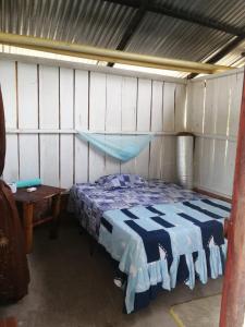 圣何塞德尔瓜维亚雷FINCA AGROTURISTICA VILLA MANE的卧室配有蓝色和白色的床和一张桌子
