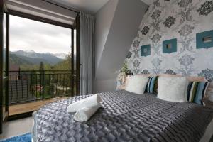 扎科帕内VIP Apartamenty Widokowe的一间卧室设有一张床和一个美景阳台