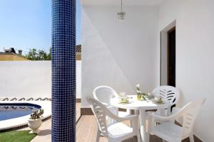科尼尔-德拉弗龙特拉Casa Cala del Aceite 2的一个带游泳池的庭院里配有一张白色的桌子和椅子