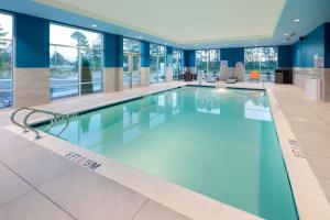 史密斯菲尔德Hampton Inn Smithfield Selma, NC的一座大型游泳池,位于一栋拥有蓝色墙壁和窗户的建筑内
