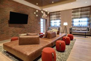 塔斯卡卢萨Homewood Suites by Hilton Tuscaloosa Downtown, AL的客厅配有沙发、椅子和电视