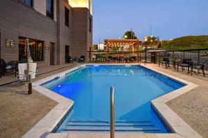 塔斯卡卢萨Homewood Suites by Hilton Tuscaloosa Downtown, AL的一个带桌椅的大型蓝色游泳池