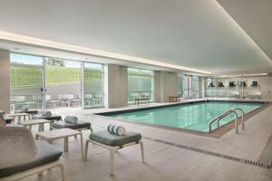 亚特兰大Embassy Suites by Hilton Atlanta Midtown的一个带椅子和桌子的大型游泳池