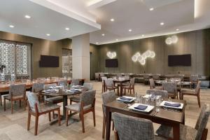 亚特兰大Embassy Suites by Hilton Atlanta Midtown的一间带桌椅和电视的用餐室