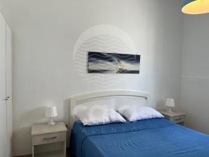 托雷拉皮罗Villa Aurora的卧室配有蓝色的床,墙上有帆船