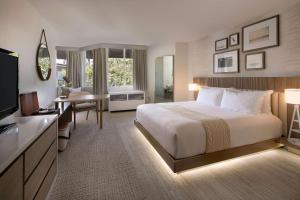 曼哈顿海滩The Belamar Hotel Manhattan Beach, Tapestry by Hilton的配有一张床和一张书桌的酒店客房