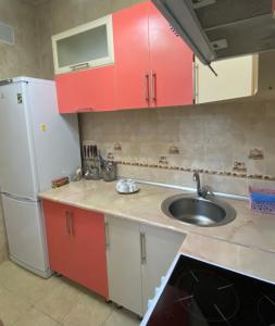 (( Turksib ))Майлина 10 аэропорт的厨房配有红色橱柜、水槽和冰箱