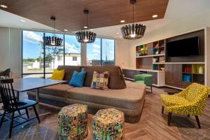 卡拉马祖Home2 Suites By Hilton Kalamazoo Downtown, Mi的客厅配有沙发和桌椅