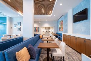 森尼维耳市Homewood Suites By Hilton Sunnyvale-Silicon Valley, Ca的一间设有桌子和蓝色沙发的等候室