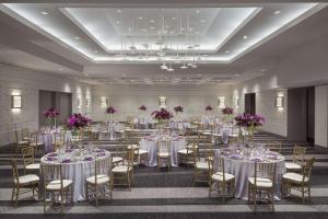 华盛顿Hilton Washington DC Capitol Hill的宴会厅配有白色的桌椅和紫色的鲜花