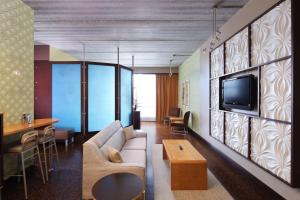 霍兰Tulyp, Tapestry Collection by Hilton的客厅配有沙发和墙上的电视