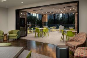 奥兰多Home2 Suites by Hilton Orlando Downtown, FL的一间带桌椅的餐厅和庭院