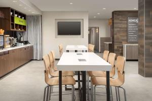 坦帕Home2 Suites By Hilton Tampa Westshore Airport, Fl的一间配备有白色桌椅的用餐室