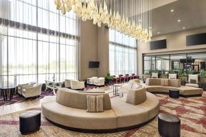 圆石城Embassy Suites by Hilton Round Rock的大堂配有沙发、椅子和吊灯
