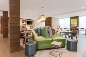 西萨克拉门托Home2 Suites By Hilton West Sacramento, Ca的客厅配有绿色沙发和桌子