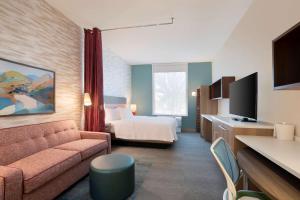 埃文代尔Home2 Suites By Hilton Phoenix Avondale, Az的酒店客房设有一张沙发和一张床