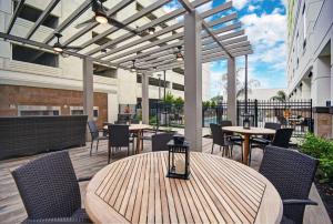 休斯顿Home2 Suites by Hilton Houston Medical Center, TX的户外庭院配有桌椅和遮阳篷。