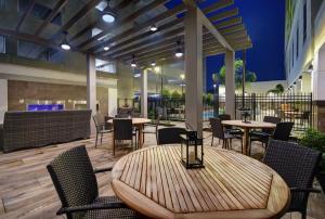 休斯顿Hilton Garden Inn Houston Medical Center, TX的一个带桌椅的庭院和一间酒吧