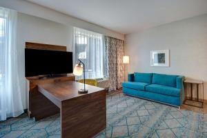 森尼维耳市Hampton Inn & Suites Sunnyvale-Silicon Valley, Ca的客厅配有蓝色的沙发和平面电视。