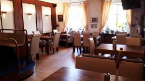 林多夫科罗内灵道酒店的用餐室设有桌椅和窗户。