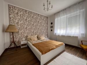 奥巴曹洛克AranyLak vendégház的一间卧室设有一张床和一面墙