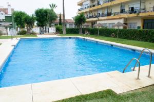 多列毛利诺斯La Cizaña Dúplex By Holiday Homes Málaga的大楼前的大型蓝色游泳池