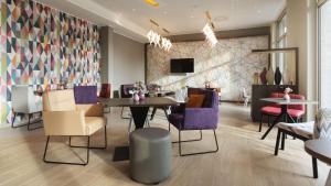 康斯坦茨Hampton by Hilton Konstanz的用餐室配有桌椅和墙壁