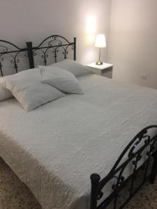 莱切Villino Donna Rita的一张配有黑色框架和白色床单的大床