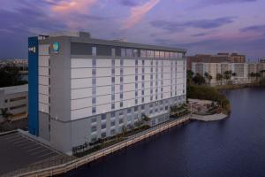 迈阿密Tru By Hilton Miami Airport South Blue Lagoon, Fl的水体旁的白色大建筑