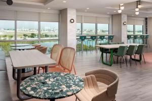 迈阿密Home2 Suites By Hilton Miami Airport South Blue Lagoon的餐厅设有桌椅和窗户。