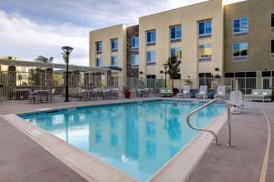 蒂梅丘拉Hilton Garden Inn Temecula的一座配有桌椅的酒店游泳池