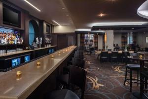 银泉DoubleTree by Hilton Silver Spring Washington DC North的餐厅内的酒吧配有桌椅