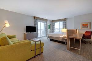蒂梅丘拉Hilton Garden Inn Temecula的酒店客房设有沙发、床和电视。